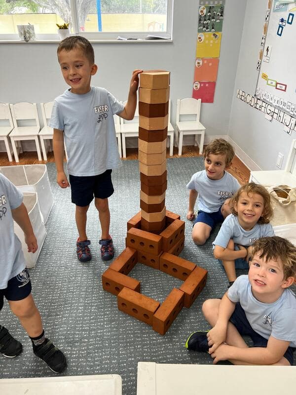 Students building a tall tower out of wooden blocks