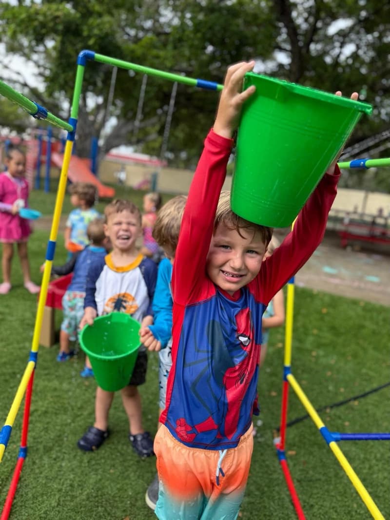 Students playing with buckets on the playground