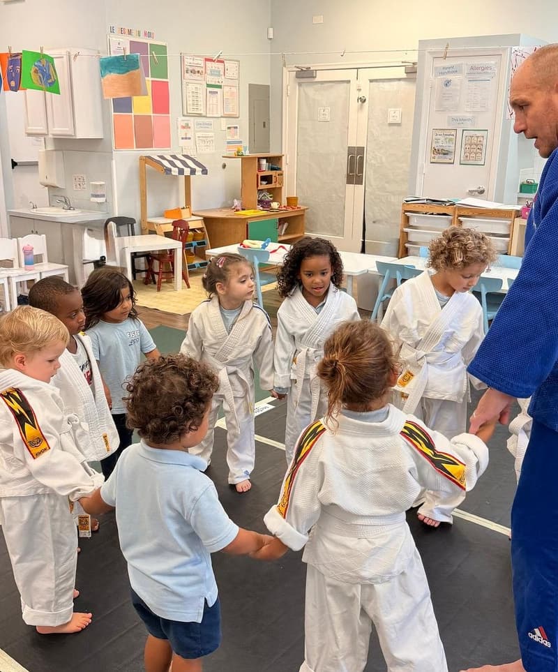 Students holding hands in a circle during judo class
