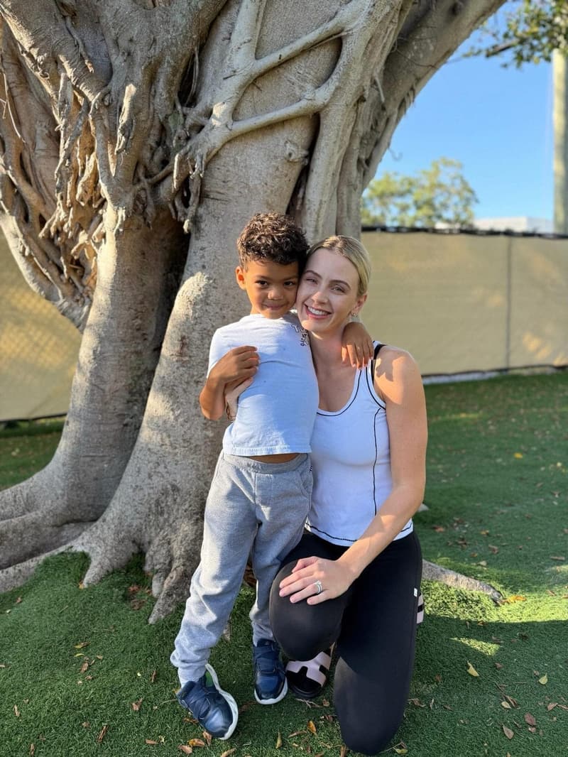 A student with his mom under the big tree