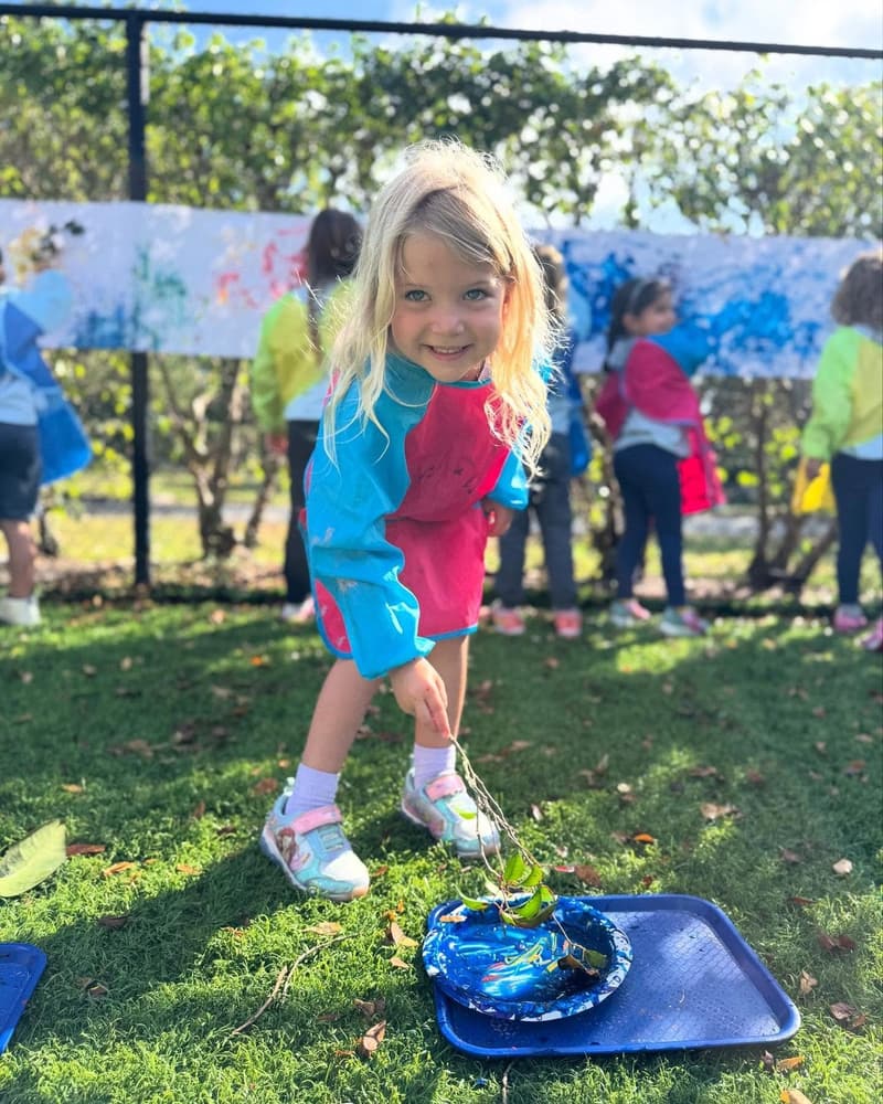 A student painting a mural outdoors