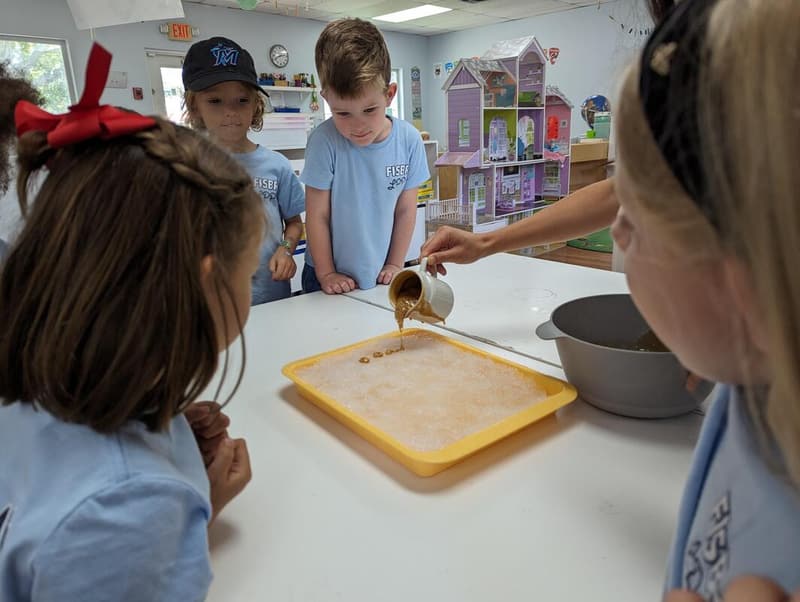 A teacher and students pouring and measuring at a sensory table