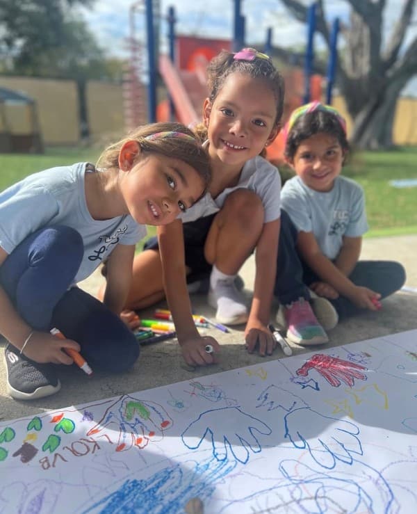 Students painting a large mural outdoors