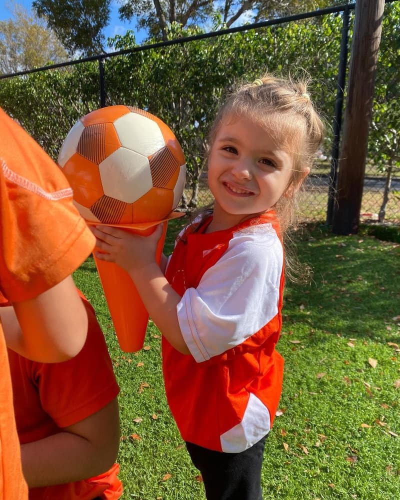 A student holding a soccer ball at Soccer Shots