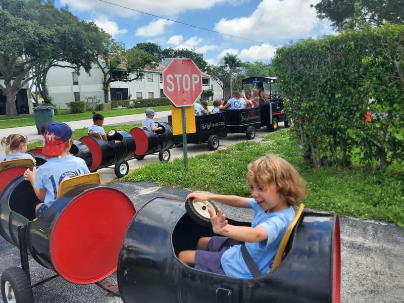 Students riding a trackless train around the school