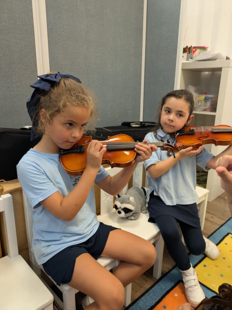 Two students learning to play the violin